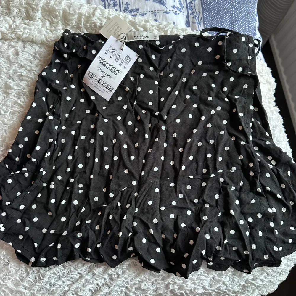 En kortare kjol från pull&bear som aldrig använts. Den har ett knyte på sidan om cg är en omlottkjol. Den är i storlek M men passar för en S. Kjolar.
