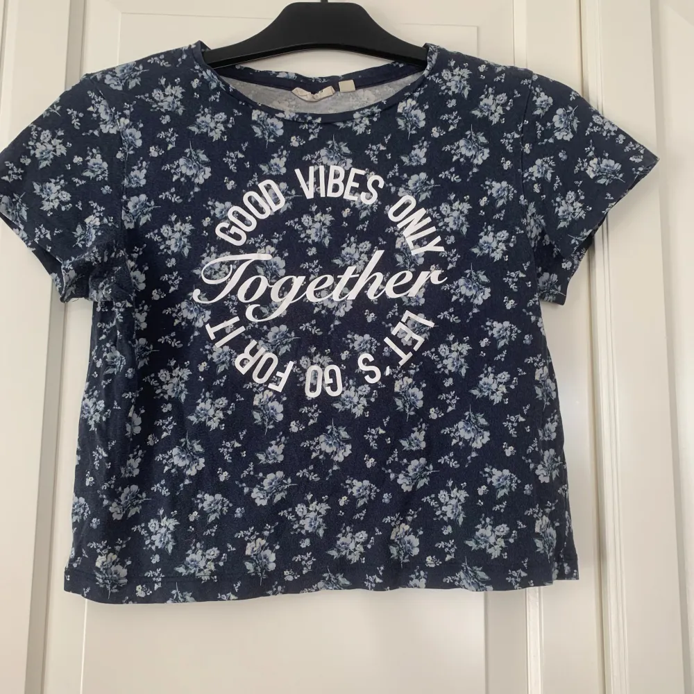 Det är en t-shirt med blommigt mönster och en text där det står ”good vibes only let’s for it together” Väl använd  Säljs för att den är för liten. T-shirts.