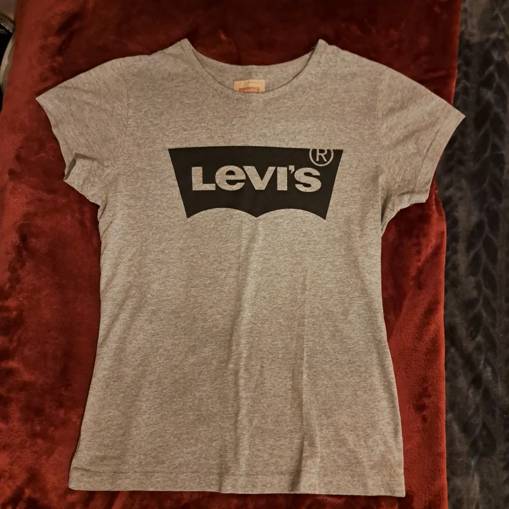 Grå T-shirt från Levi's i bra skick. Skulle säga att de är en XS. Säljs då den inte kommer till andvänding längre. Bredd 38,5 cm, Längd 57 cm. Köparen står för frakten. Skriv vid funderingar💕. T-shirts.