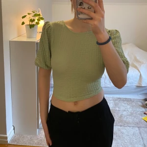 Topp med öppen rygg - Supersöt grön topp från Gina Tricot i storlek M. Knyts i ryggen och går därför att justera storleken. Endast använd enstaka gånger, så den är som ny! 🌟