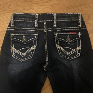 Lågmidjare True Religion liknande jeans  - Säljer dessa raka True Religion liknande jeansen från Cipo&Baxx💗Så coola med unika bakfickor och sömmar. Midjemått=36 cm rakt över + lite stretch, innerben=79 cm