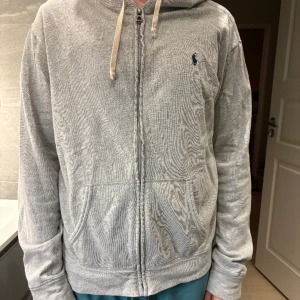 Ralph Lauren zip hoodie  - Fräsch ljus grå zip hoodie från Ralph lauren i storlek large. Modell är 178cm och väger 75kg. Hoodie är 100%  bomull och är mer till för våren/hösten. 