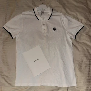 Kenzo Piké Tröja - En vit Kenzo Piké Tröja som är använd ett fåtal gånger. Inga fläckar eller hål. Storlek L. Digitalt kvitto från Farfetch kan skickas. Kostade 1147kr ny. Frakt kan fixas!