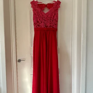 Balklänning - Säljer min superfina balklänning i färgen röd. Storlek S/M. Den enda skavanken är att knappen längst ned på baksidan är sydd. Nytvättad. Inköpt för 4000kr säljer för 800kr. 