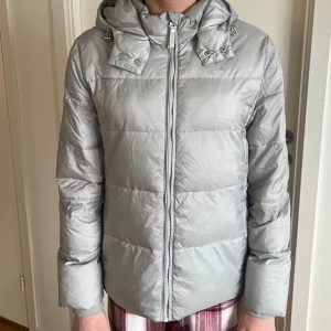 Grå dunjacka från GANT - GANT dunjacka grå med luva, storlek 170cm, använd endast en gång så som helt ny!! Rosa foder på insidan