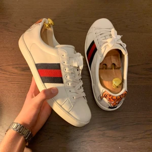 Gucci Ace - Limited edition Tiger patched Gucci Ace skor i riktigt bra skick! Skick 9/10. Nypris är runt 5000 kr och vårat pris är 2599! Inget og ingår. Storlek 44.5 passar möjligtvis 45. Dessa skor är sällsynta i detta skick. INGA BYTEN TAS EMOT. Är creasade. 
