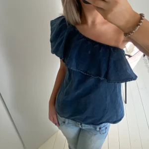 One Shoulder tröja - Säljer den här otroliga toppen med en superfin volang och hela är perfekt men använder tyvärr aldrig längre! 