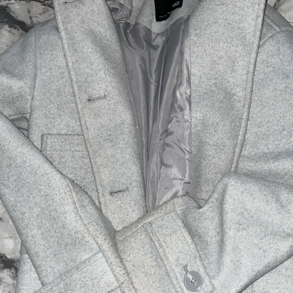 Jag säljer den här kappan för jag har tröttnat på den,använd men hel utan skador i färg grå och storlek xs,märke lager 157 . Jackor.