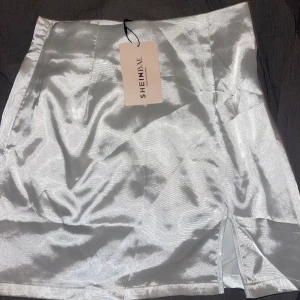 Kjol - Säljer denna satin kjolen från shein med dragkedja på sidan. Aldrig använd därav är lappen kvar