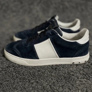 Valentino Flycrew  - Valentino Flycrew i den eftertraktade färgen mörkblå. Storlek 39,5. Nyskick förutom att en nit saknas. Inget mer än skorna medföljer. Nypris 6899kr men går inte att få tag på längre då de slutats produceras, köp för endast 3199kr.