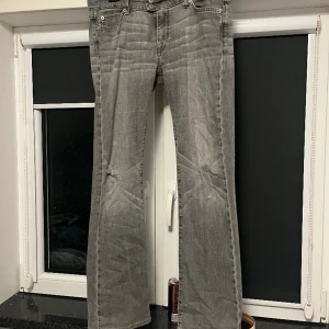 Supersnygga lågmidjade gråa jeans - Gråa lågmidjade jeans, stretchiga material så passar flera storlekar! Har ett litet hål på ena benet men det har bara jag tyckt var snyggt. Älskar bakfickorna. Behöver dock tyvärr sälja för har inte plats💕