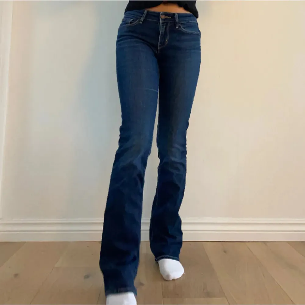 Säljer dessa mörkblå Lågmidjade bootcut jeans från Levis som är i väldigt bra skick! Midjemått: 38cm Innerbenslängd: 88cm. Storlek passar S. Skriv för frågor!🫶🏼🩷. Jeans & Byxor.