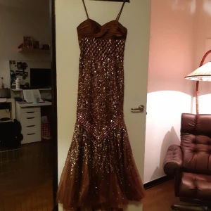 Balklänning - Bra skick, endast använd en gång. Nypris 7500kr. Paljetter och stenar varierar i storlek. Klänningen har ett litet släp och underkjol ingår i köpet. Även sjal och handväska ingår.   Finns i Emmaboda/levereras till Växjö, Ljungby, Karlshamn, Kalmar. 