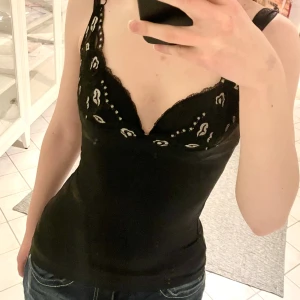 Svart festtopp - Jättesnygg svart topp med fina detaljer fram och bak. Jättebra skick, är tajt och stretchig så passar jättefint för XS-S <3  Pris kan diskuteras! 