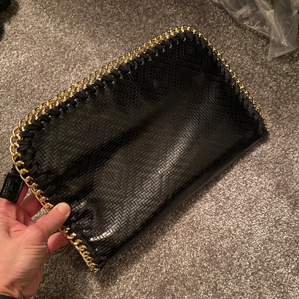 Kuvertväska i svart med guldkant och fint mönster, använd ett fåtal gånger . Väskor.