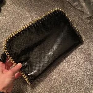 Kuvertväska i svart med guldkant och fint mönster, använd ett fåtal gånger 