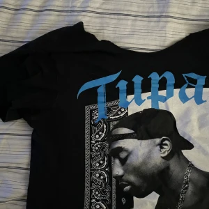 Tupac T-shirt utan krage.  - Köpt på wodooland för 350kr. ❤️ Sitter väldigt fint om du gillar lite mer baggy stil. Storlek L men passar som M. Trycket är inte slitet alls. Använd under förra året lite men annars inte mycket. ❤️ hör av er först vid köp. 