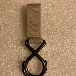 *NY*Grå krok för barnvagn  - Dubbelkrok för barnvagn i hårdplast med kardborreband.