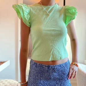 Limegrön topp - Limegrön topp med fina detaljer. Säljer även en fast vit