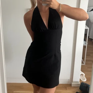 Svart klänning - Jättefin svart klänning från H&M. Använd 1-2 gånger. Justerbar uppe vid nacken! Är storlek 38 men brukar i vanliga fall ha 36. Även en dragkedja på sidan.