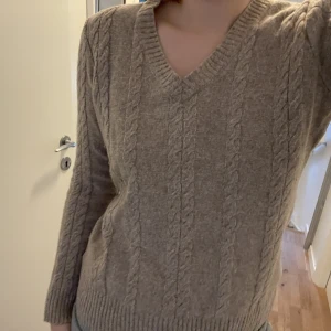 Kabelstickad beige tröja - Superfin stickad tröja som sitter bra. Bra kvalitet och bra skick, men tyvärr är den inte min stil.