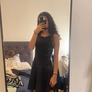 En svart klännig - En svart klännig men blommiga mönster vid midjan på båda sidorna.