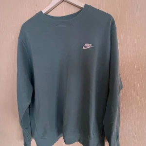 Nike collagetröja - Nike collegetröja, turkos. Använd men i bra skick. Nypris cirka 1500. 