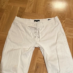 Vita byxor  - Skit snygga vita cargoliknande byxor med snörning!! Lågmidjade o lite bootcut modell💖Midjemått: 43cm, Innerbenslängd: 71cm! Använd gärna nu!!