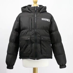Hoodrich puffer jacket size S - In a black colourway, this jacket is made from nylon and polyester. It features a full zip fastening, button fastening pockets, fixed hood, nylon fill and is finished with banding to the chest in white and on the back in black.