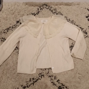 Zara kofta - Jättefin kofta från zara med volanger. Storlek 128 men kan passa 146 också om man viker upp armarna lite grann. Har lite smuts på baksidan på armarna.pris kan diskuteras ❤️