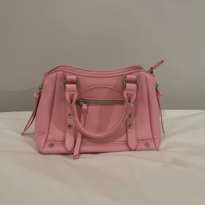 Rosa väska nakd - Snygg rosa väska från nakd i nyskick. Långt band medföljer. Skriv för fler bilder eller andra funderingar. Andra bilden är lånad😊