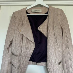 By Malina biker jacka - Så snygg beige bikerjacka från Malina, med lila foder. Använd och älskad, vanligt slitage, hål vid lappen, se bild. Inköpt för några år sedan för 2400kr