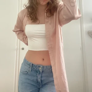 Satinskjorta - En skön och luftig satinskjorta i färgen ljusrosa!💕 Den är i storlek S men en aning oversized. Perfekt till sommaren ovanpå exempelvis en fin vit outfit kanske?☺️