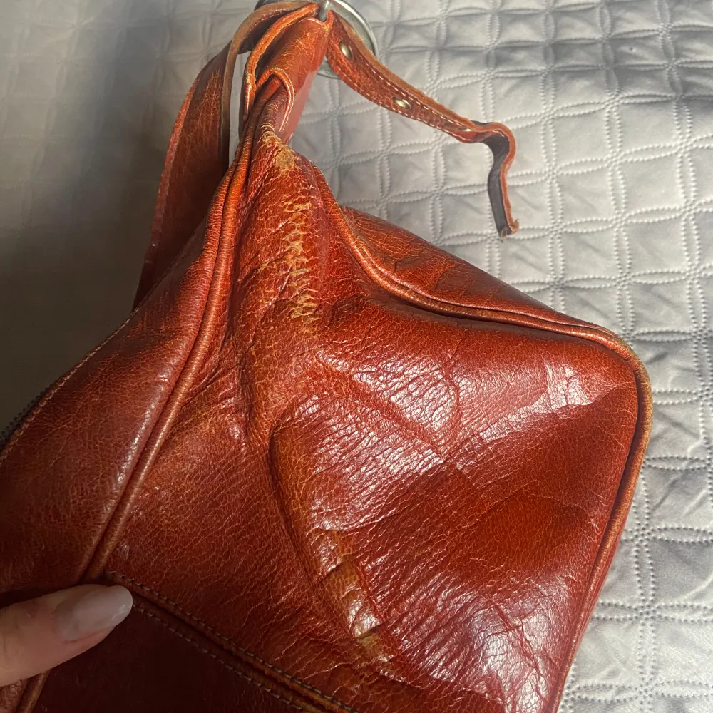 Säljer denna ”vintage” väska då jag behöver rensa ut! Vet ej märket. Den är sliten, vilket jag tycker är en snygg detalj. I en ”mörkorange” färg, balenciaga likande. Väskor.