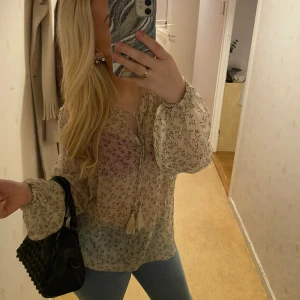 Blus med blommor  - Så fin blus med blommor på, går att knyta med snörena där uppe om man vill, den e aldrig använd, storlek s-m💓