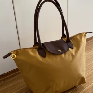 Longchamp liknande väska -  Säljer min super fina longchamp liknande väska, jag har köpt den second hand men inga tydliga deffekter på utsidan. Perfekt storlek då den är rymlig. Den har en ficka på insidan, se bild 3 för att se att det är en liknande. Kontakta för mer info 💗 