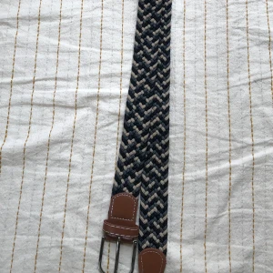 Flätat bälte - Flätat bälte i nyskick! Med färgerna beige, svart och grå