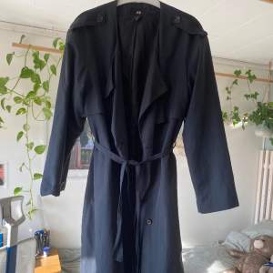 Trenchcoat som inte kommer till användning av mig. Storlek 40, sitter oversize på mig med 36. Går att dubbelknäppa och är då rund i halsen.