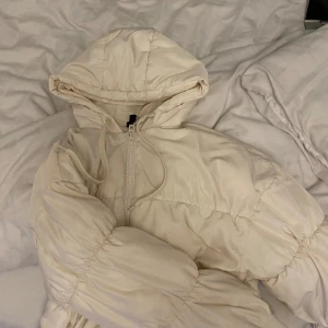 Vit kort puffer jacka - Det är en vit puffer jacka från hm den är i fint skick, använd Max fem gånger säljer då den ej kom till användning.