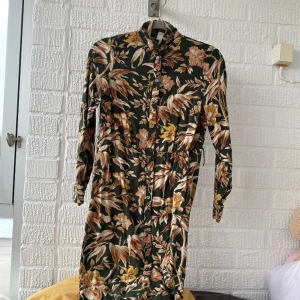 Blommig klänning  - Jag vill sälja denhära blommiga klänningen. Den är grön med blommor på. Den har Inga skador. Priset går att diskutera!