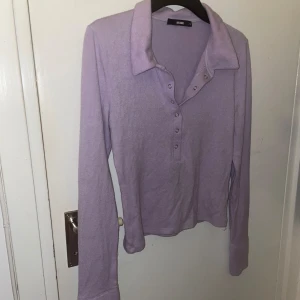 Lila tröja med knappar - En lila tröja med knappar. Den är varm och mysig, samtidigt färgglad. Storlek M och är köpt från Bikbok.