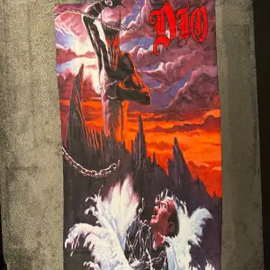 DIO Holy Diver Flagga Från Albumet: Holy Diver -83🔥 Ska egentligen vara ett Badlackan men rekommenderar att använda som flagga på vägg!🏴‍☠️🔥 Skick: Typ som ny! Mått: 157x80cm (Som ett badlackan bra precis) Pris: 199kr Köparen står för eventuell frakt!