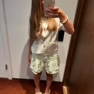 Vit kortärmad kofta från Zara - Säljer en superfin vit kortärmad kofta från Zara. Den är i storlek S och har snygga guldfärgade knappar framtill. Koftan har två fickor på framsidan och är perfekt för både vår och sommar. Den är i nyskick och väldigt bekväm att ha på sig. Passar perfekt till både jeans och kjol!