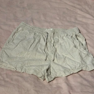 Beige shorts från H&M - Säljer ett par bekväma beige shorts från H&M i storlek S. De är gjorda av linne och har en elastisk midja för extra komfort. Perfekta för sommaren!