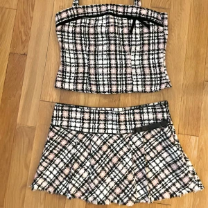 Set kjol +topp  - Minikjol + haltertop set i Rosa vitt och svart. Storlek ”176” men passar som en M. Kjol mått: 42 cm   topp: 38 cm.    Aldrig använd. Fint skick!:)