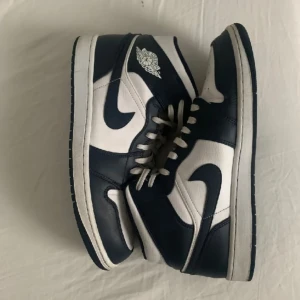 Air Jordan 1 mid  - Storlek 45 men passar även 44  Färg: White Metallic Gold Obsidian Skorna är använda men fortfarande i bra skick  Ny pris 1400 , Crease skydd ingår !  Säljer pga att jag fick nya skor. Bara att skriva om du har några frågor !
