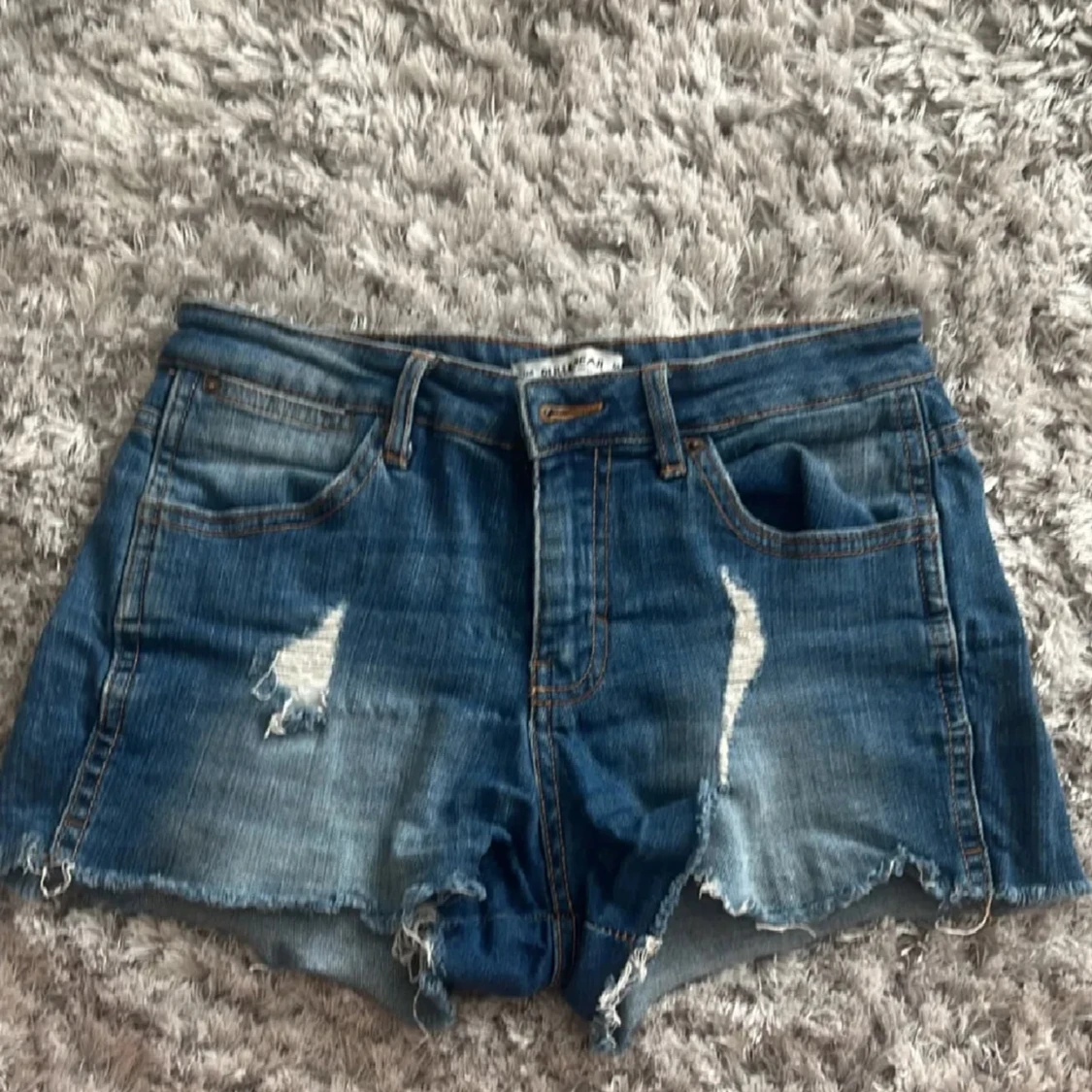Blå jeansshorts med slitningar