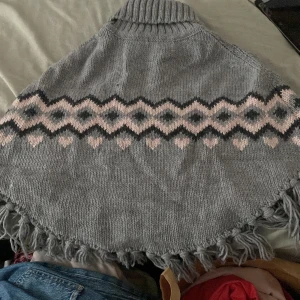  Poncho -  En grå poncho med rosa detaljer väldigt mysigt faktiskt faktiskt