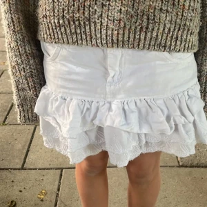 Vit jeanskjol - Low waist ”jeans” kjol med volanger på. Köpt secondhand. Midjemåttet är 37 tvärs över och 70 i omkrets. Tvättas innan köp! Skriv för fler frågor och bilder! KÖP DIREKT för 450 kr!