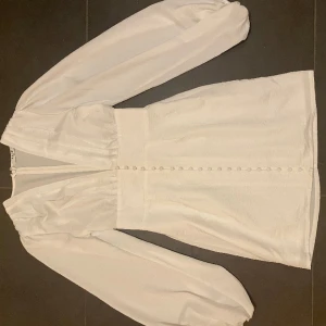 Miniklänning med knappdetaljer - NAKD - Klänning från NAKD, LIKNANDE andra bilden men inte samma! Nästan aldrig använd pågrund av att den är lite för stor för mig, inga defekter💕Nypris 700💕Skriv för ytterligare frågor eller bilder✨